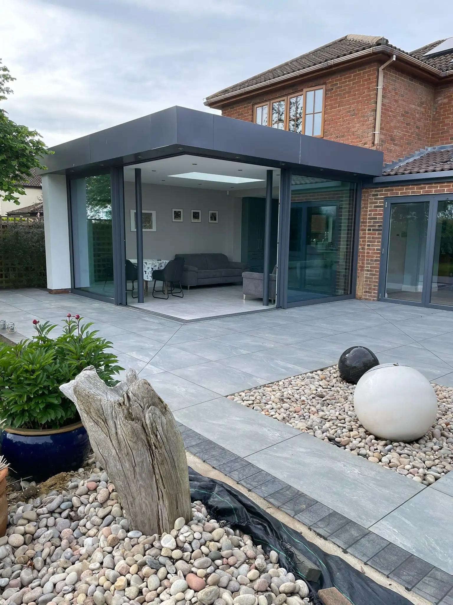 Garden room with porcelain paving and pebble beds